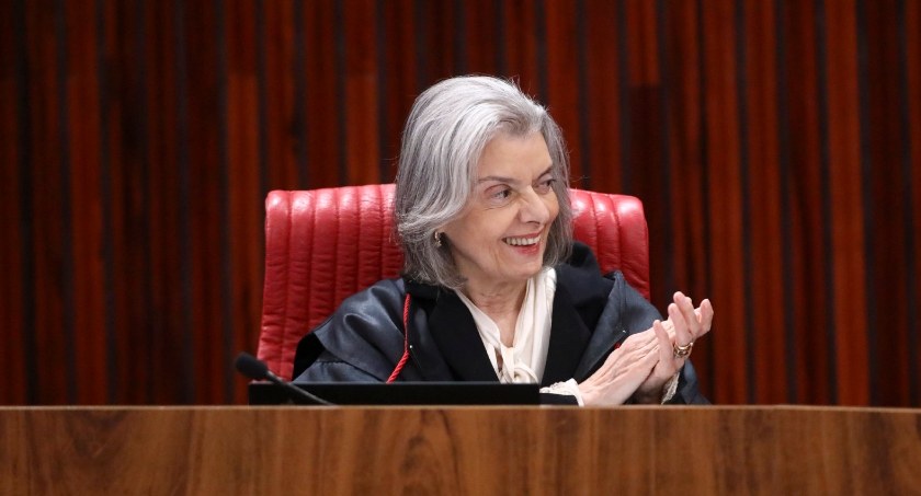 Foto da ministra Carmem Lúcia no Plenário do TSE. A ministra está vestindo toga, sentada numa po...