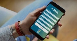 A foto mostra uma mão segurando um smartphone na vertical. Na tela do celular aparece o aplicati...