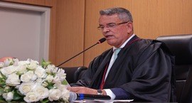 Grupo de 10 autoridades reunidas em torno de uma grande mesa redonda em sala institucional , ten...