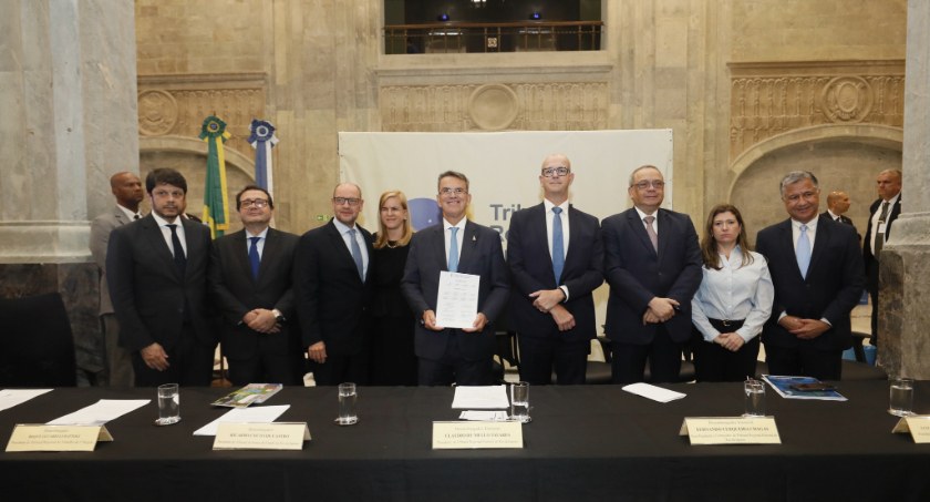 Imagem de autoridades, atrás de uma mesa, após a assinatura de um pacto interinstitucional contr...