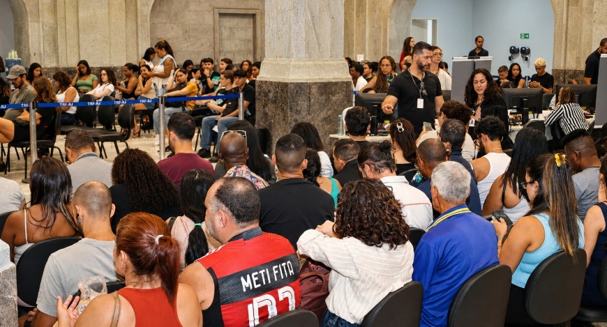 Público sentado em filas dentro do Palácio da Democracia, aguardando atendimento, enquanto fserv...