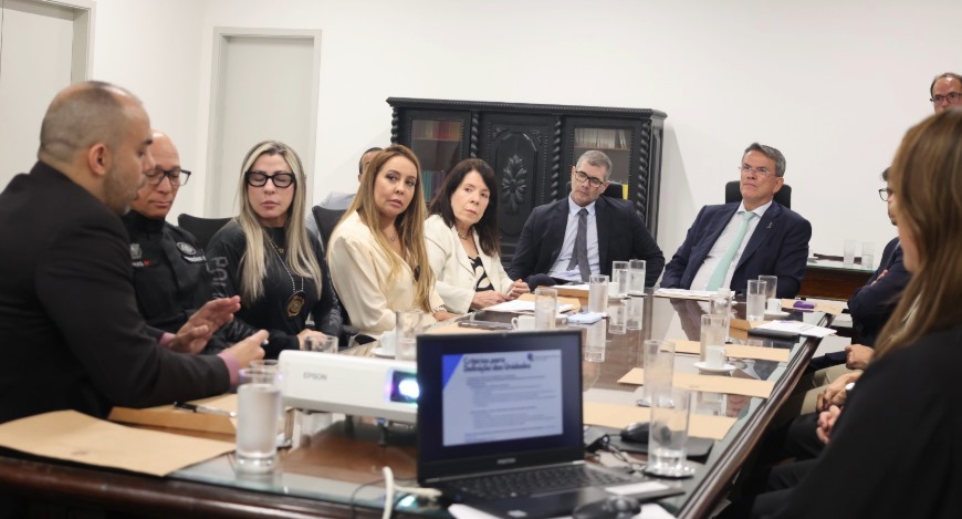 Autoridades estão sentadas em volta de uma mesa durante a reunião do projeto "Democracia Além da...