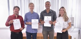 TRE-RJ Justiça Eleitoral fluminense recebe novos servidores Foto posada dos quatro novos servidores do TRE-RJ; todos seguram o termo de posse. Da esquerda p...