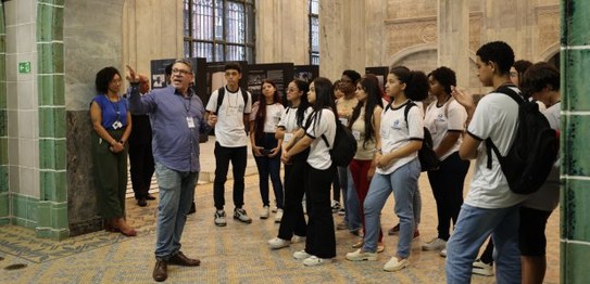 Um grupo de pessoas de diversas idades posa no plenário do TRE-RJ.