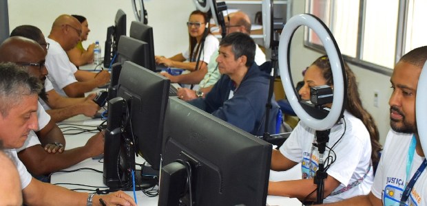 Atendimento itinerante beneficia eleitoras(es) em Miguel Pereira e Paty do Alferes Guichês de atendimento em Paty do Alferes; fileira de balcão com computadores e refletores de fo...