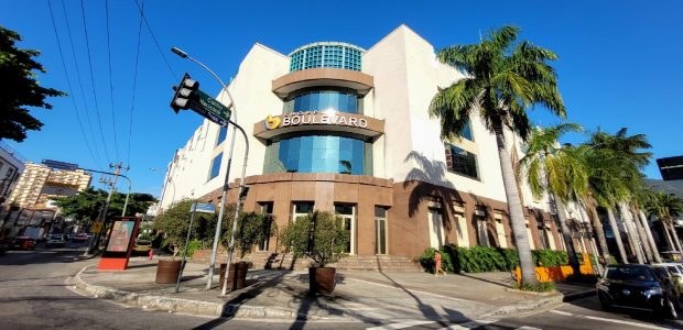 Biometria: atendimento itinerante do TRE-RJ chega ao Shopping Boulevard Foto da fachada do Shopping Boulevard. O edifício é branco, com detalhes em marrom, e possui uma...