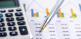 A imagem mostra uma cena de planejamento financeiro vista em plano detalhe, com foco suave no fu...