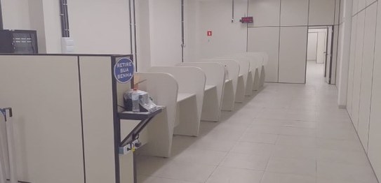 A imagem mostra um espaço interno com um ambiente organizado e minimalista. Há uma fileira de ca...