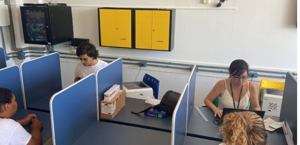 Cerca de 400 jovens do ensino médio participam de ação do TRE-RJ em Rio Bonito Num balcão de atendimento, uma servidora e um servidor do TRE-RJ atendem duas jovens