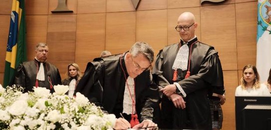 Desembargador Claudio de Mello Tavares assina termo de posse; ao lado o desembargadro Fernando C...