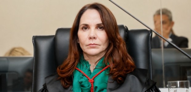 A desembargadora eleitoral Maria Paula Galhardo usa toga preta e faixa verde com cordão vermelho.
