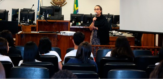 Estudante tem a sua digital coletada para o cadastramento biométrico. A servidora segura o seu d...