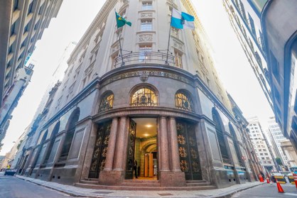 A foto mostra um prédio em pedra escura, ele fica na esquina entre duas ruas