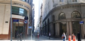 Descrição da imagem: Rua com os prédios Sulacap e o Tribunal Regional Eleitoral do Rio de Janeir...