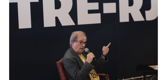 A imagem mostra um grande painel com o nome do seminário em letras destacadas, usando uma mistur...
