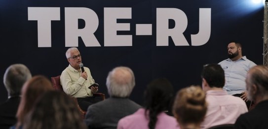 A imagem mostra um grande painel com o nome do seminário em letras destacadas, usando uma mistur...