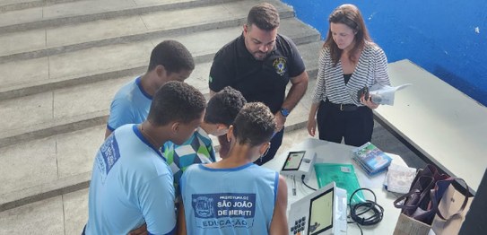 A imagem mostra um grupo de estudantes usando uniformes azuis com o logotipo da Prefeitura de Sã...