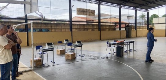Turma de estudantes sentados em cadeiras verdes, assistindo a uma palestra conduzida por juíza. ...