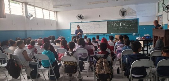 Grupo de estudantes sentados assistindo a uma palestra realizada por magistrada