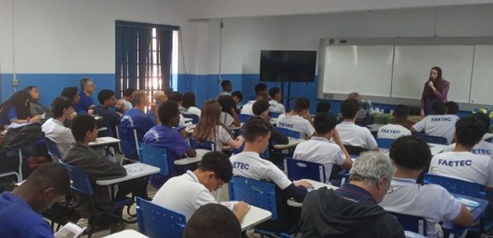 Grupo de estudantes sentados assistindo a uma palestra realizada por magistrada