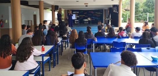 Grupo de estudantes sentados assistindo a uma palestra realizada por magistrada
