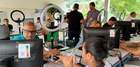 Ambiente de atendimento ao público montado em um espaço coberto e arejado, com diversas pessoas ...
