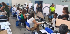 A imagem mostra um mutirão de atendimento realizado em um espaço fechado, com diversas pessoas s...