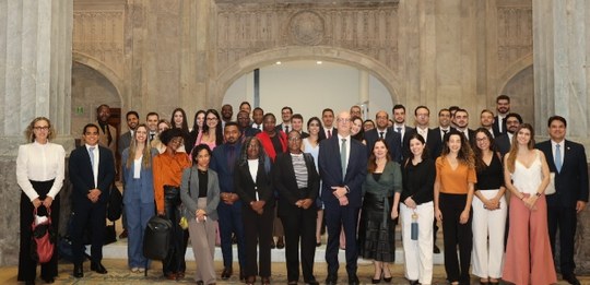 Cerca de 40 magistradas e magistrados estão reunidos de pé no Grande Hall do Palácio da Democracia