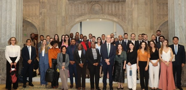 Cerca de 40 magistradas e magistrados estão reunidos de pé no Grande Hall do Palácio da Democracia