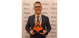 Michel Kovacs posa com troféu, em formato piramidal, ao lado de dez integrantes da equipe da TI,...