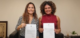 Novas servidoras Erika Spitz Paiva e Victoria Pereira Baptista posam segurando o termo de posse....