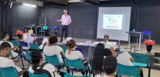 Numa sala de aula, em primeiro plano, sentados e de costas, estudantes do CIEP 364 Nelson Ramos,...