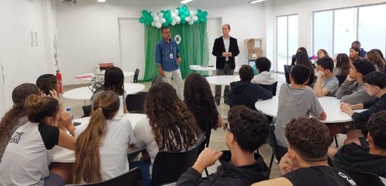 Numa sala, sentadas(os), estudantes assistem à palestra do juiz eleitoral Livingstone dos Santos...
