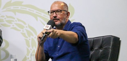 Três pessoas estão sentadas em um semicírculo; da esquerda para a direita, Ana Flávia Magalhães ...