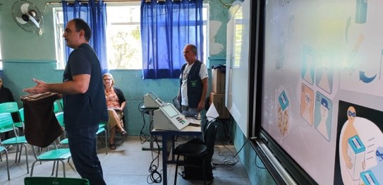 A imagem mostra uma apresentação do projeto "Eleitor do Futuro" em um auditório escolar. Um home...