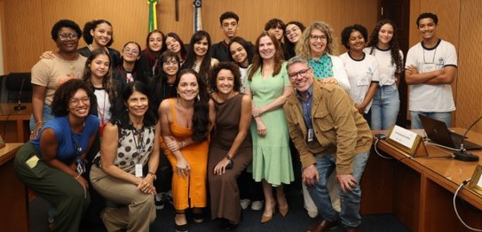 Um grupo de pessoas de diversas idades posa no plenário do TRE-RJ.