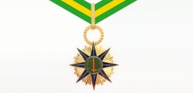 A Medalha do Mérito Eleitoral, que tem um formato de estrela com pontas douradas e azuis-escuro,...