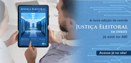 Duas pessoas seguram um tablet com a capa da revista “Justiça Eleitoral em Debate”, com visual t...