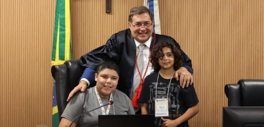 A jovem com aparelho auditivo e óculos realiza o procedimento de coleta biométrica para emissão ...