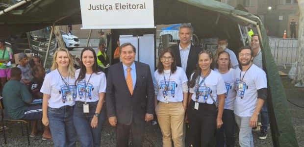 Presidente do TRE-RJ participa da abertura da Semana Nacional do Registro Civil no Centro do Rio O presidente do TRE-RJ, de terno azul-marinho, está sorrindo e de pé, ao lado de servidoras e se...