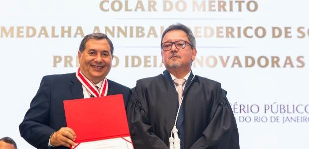 Presidente do TRE-RJ recebe Colar do Mérito do MPRJ Presidente Peterson Simão posa segurando um certificado, com a medalha ao peito, usando terno e ...