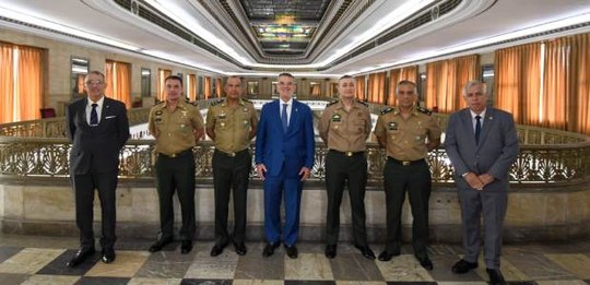 Foto posada em amplo salão institucional com vitrais no teto; no centro, o desembargador Claudio...