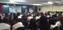 foto de auditório com servidor à frente, palestrando