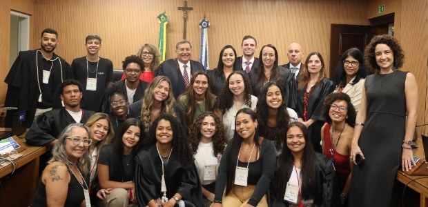Projeto “Visitas ao TRE” recebe jovens universitários para atividades educativas A imagem mostra um grupo de pessoas reunidas em uma sala institucional, possivelmente de sessões...