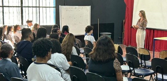 Descrição da imagem: À direita, o juiz Otávio Mauro Nobre, de camisa azul, projeta uma apresenta...