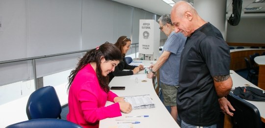 A imagem mostra o interior de uma secção eleitoral da Justiça Eleitoral brasileira durante um pr...