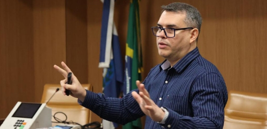 A jovem com aparelho auditivo e óculos realiza o procedimento de coleta biométrica para emissão ...