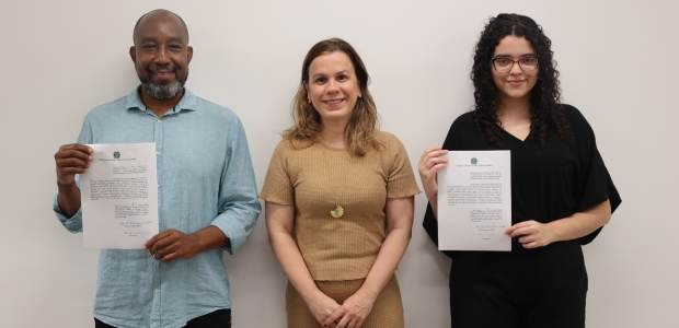 Foto posada da diretora-geral, Eline Iris, (ao centro), de camisa bege; João Cleber Ângelo (esq....