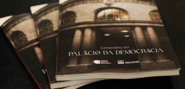 TRE-RJ comemora 100 anos do Palácio da Democracia com obra especial A imagem mostra três exemplares de um livro intitulado “Centenário do Palácio da Democracia”, co...