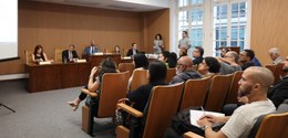 Descrição da imagem: Sentados nas cadeiras do auditório do TRE-RJ, homens e mulheres participam ...